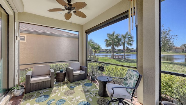 sunroom featuring a water view and ceiling fan