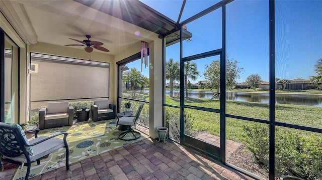 sunroom / solarium with a water view and ceiling fan