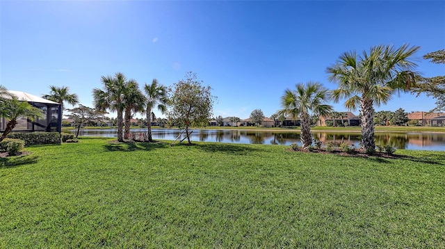 view of yard featuring a water view and glass enclosure