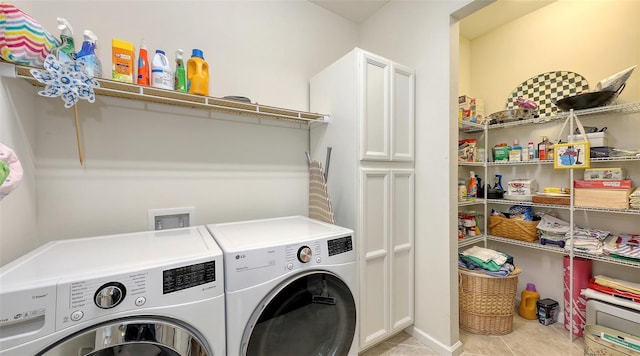 clothes washing area featuring cabinets, light tile patterned floors, and separate washer and dryer