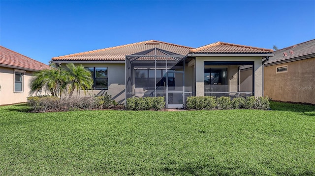 back of house featuring a lawn and a lanai