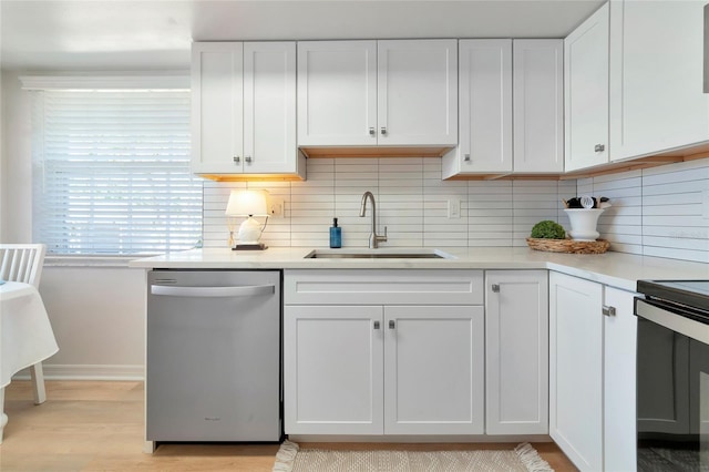 kitchen with white cabinetry, stainless steel dishwasher, sink, and decorative backsplash