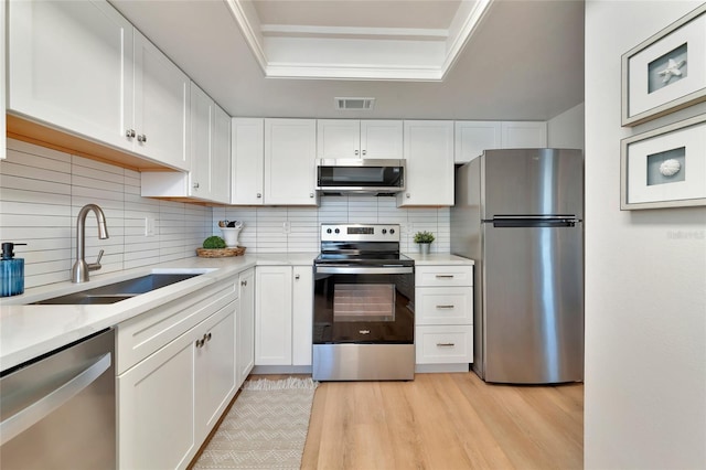 kitchen featuring white cabinetry, sink, and appliances with stainless steel finishes