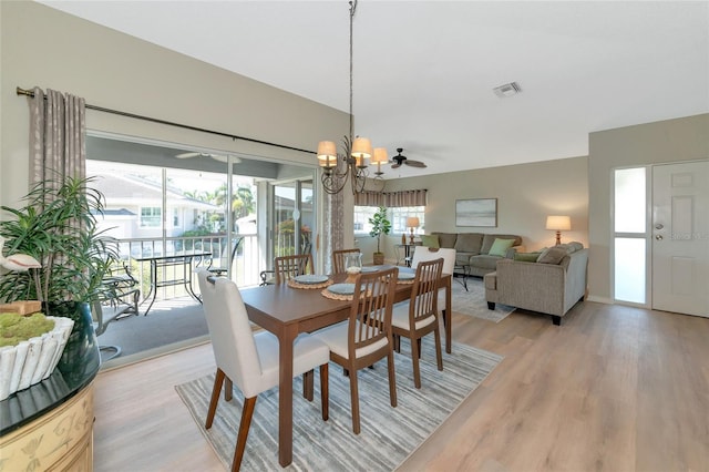 dining area with ceiling fan with notable chandelier and light hardwood / wood-style floors