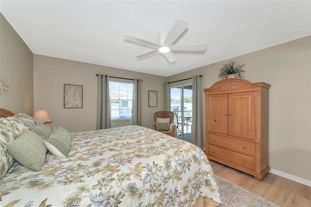 bedroom featuring access to exterior, a textured ceiling, light hardwood / wood-style flooring, and ceiling fan