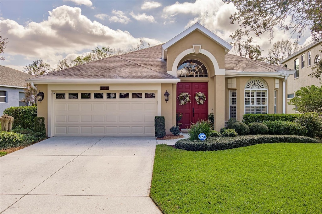 view of front of home with a garage and a front lawn