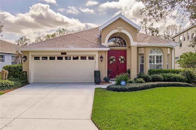 view of front of home with a garage and a front lawn