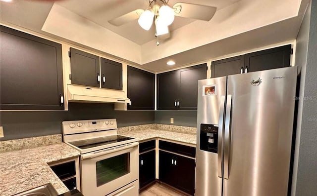 kitchen featuring light stone countertops, stainless steel fridge, white electric stove, and ceiling fan