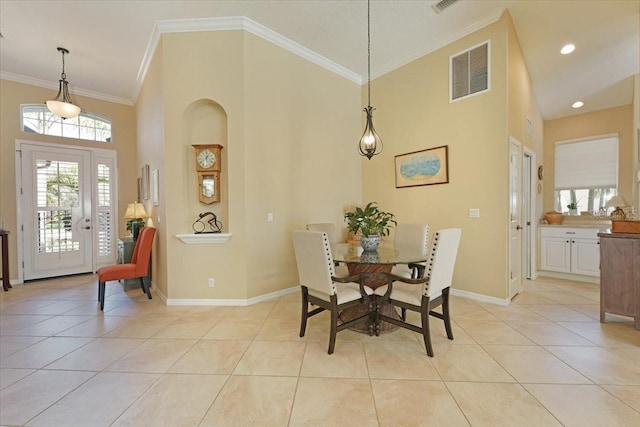 dining room with crown molding, light tile patterned floors, visible vents, a high ceiling, and baseboards