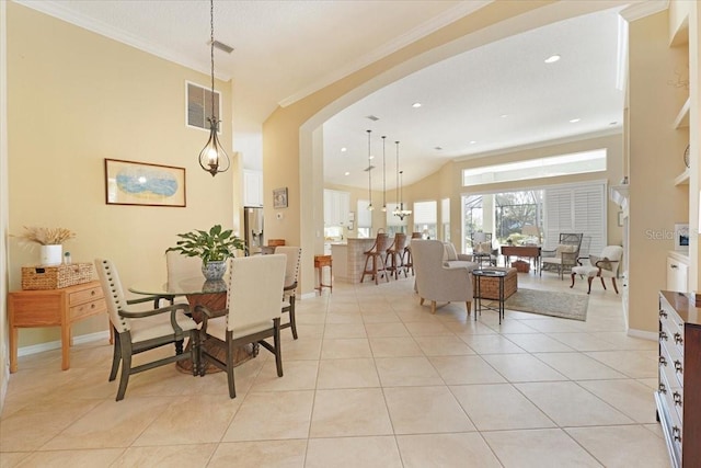 dining room featuring light tile patterned floors, visible vents, arched walkways, baseboards, and crown molding