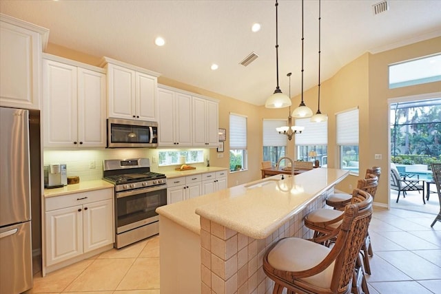 kitchen featuring stainless steel appliances, light countertops, visible vents, light tile patterned flooring, and a sink