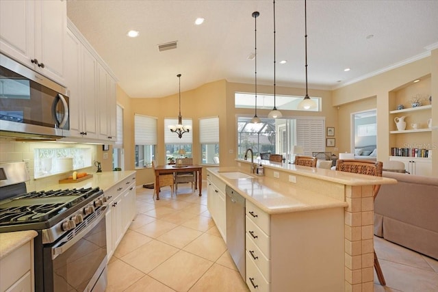 kitchen with light tile patterned flooring, stainless steel appliances, a sink, a kitchen breakfast bar, and light countertops