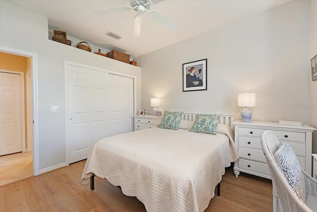 bedroom with a ceiling fan, light wood-type flooring, a closet, and visible vents