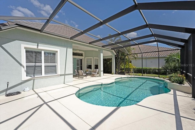 outdoor pool featuring a patio and glass enclosure