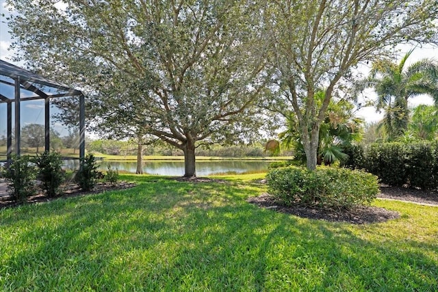 view of yard featuring a lanai and a water view