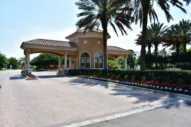 view of road with a gated entry and curbs