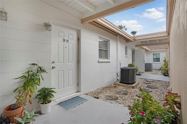 view of exterior entry with concrete block siding and cooling unit