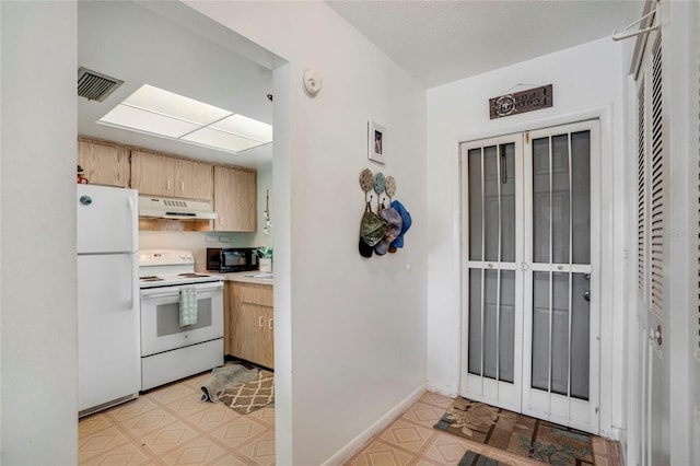 kitchen with light floors, visible vents, light countertops, white appliances, and under cabinet range hood