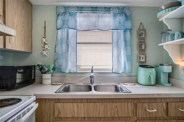 kitchen with light countertops, range hood, a sink, and brown cabinets