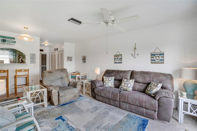 living area with ceiling fan, visible vents, and light colored carpet