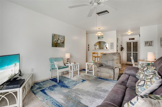 living room featuring carpet floors, visible vents, and a ceiling fan