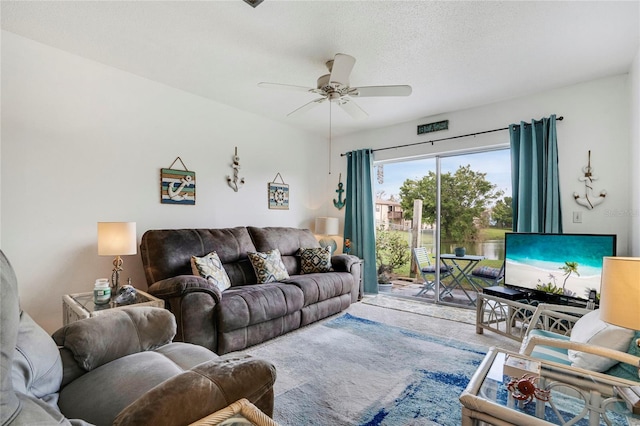 living area featuring ceiling fan and a textured ceiling