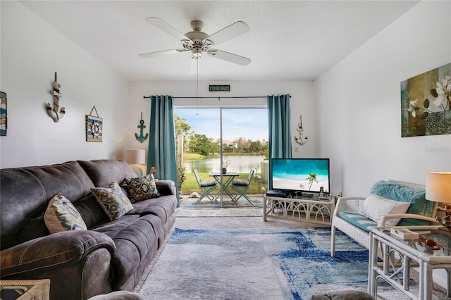 carpeted living area featuring ceiling fan and a textured ceiling