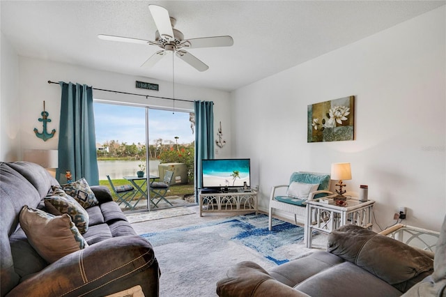 living area featuring carpet, a textured ceiling, and a ceiling fan