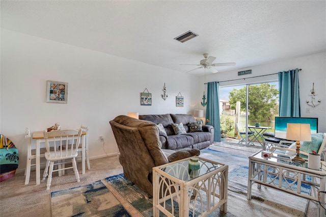 carpeted living area featuring baseboards, ceiling fan, visible vents, and a textured ceiling