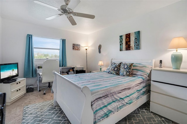 bedroom with a ceiling fan, dark colored carpet, and a textured ceiling