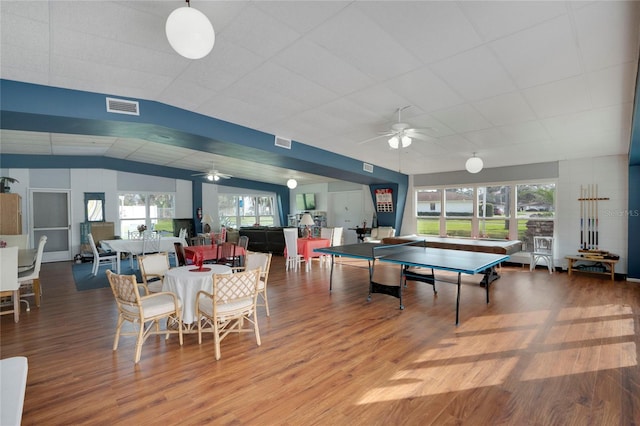 playroom with a ceiling fan, visible vents, vaulted ceiling, and wood finished floors