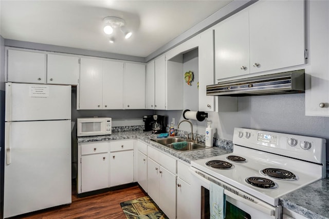 kitchen with under cabinet range hood, white appliances, a sink, white cabinetry, and dark wood finished floors