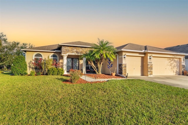 view of front of property with a garage and a lawn