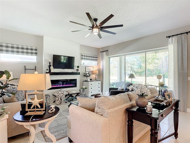 living room featuring ceiling fan and a textured ceiling