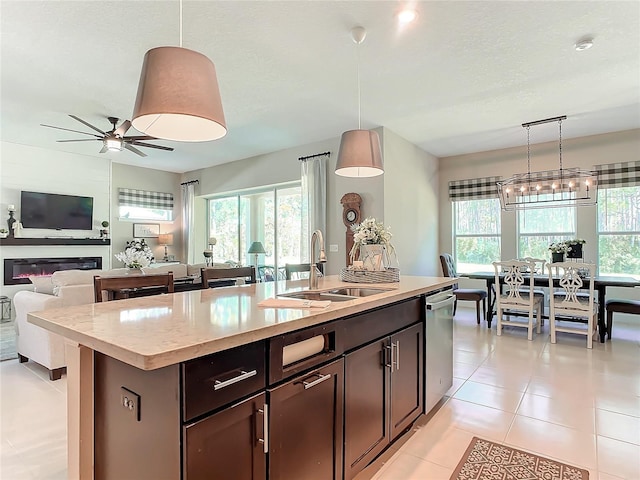 kitchen with pendant lighting, sink, dishwasher, and a center island with sink