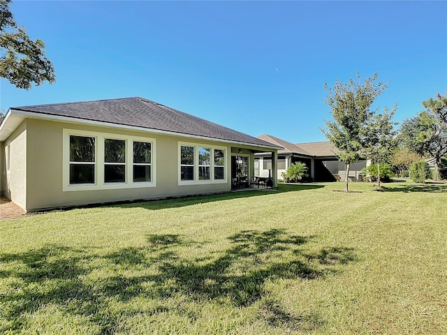 rear view of property with a lawn