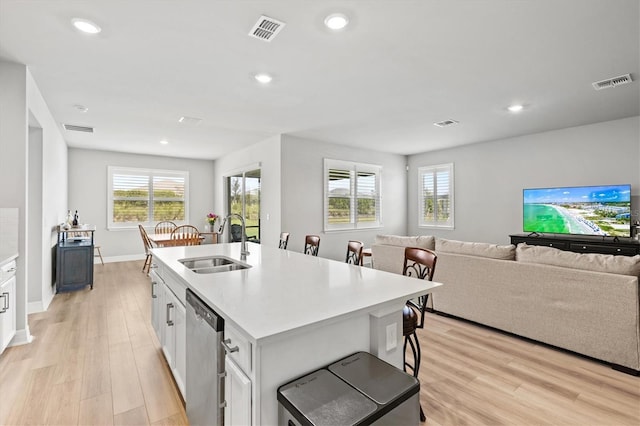 44325 Saddlewood Ct, Punta Gorda, FL 33982 - kitchen featuring dishwasher, light wood-style flooring, open floor plan, white cabinetry, and recessed lighting