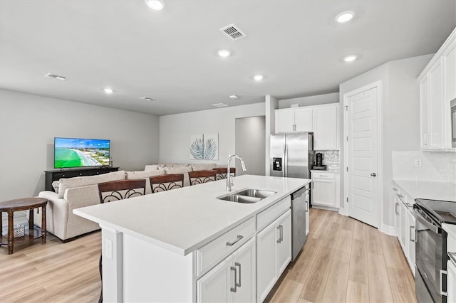 44325 Saddlewood Ct, Punta Gorda, FL 33982 - kitchen featuring appliances with stainless steel finishes, light wood finished floors, white cabinetry, light countertops, and recessed lighting