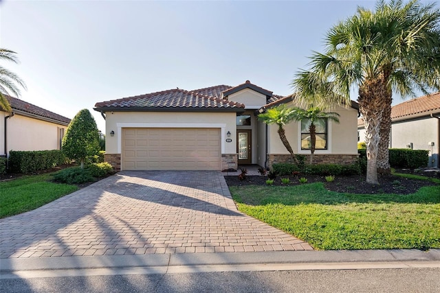 view of front of home featuring an attached garage, stone siding, decorative driveway, and stucco siding