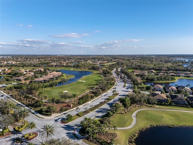 drone / aerial view with view of golf course, a water view, and a residential view