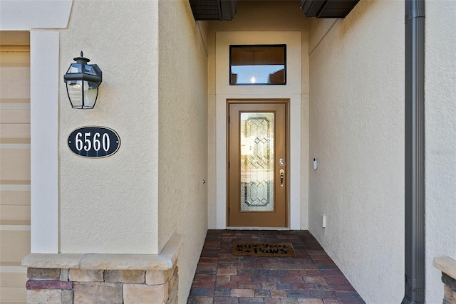 view of exterior entry with stucco siding
