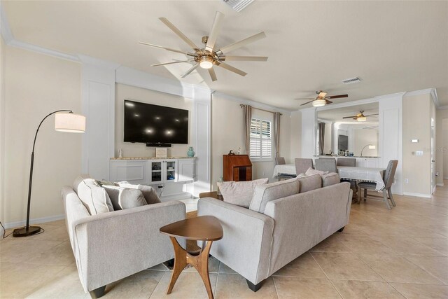 living room featuring light tile patterned floors, baseboards, visible vents, and crown molding