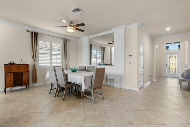dining room with light tile patterned floors, a ceiling fan, baseboards, visible vents, and crown molding