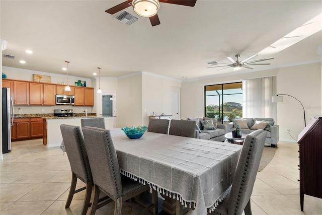 dining space with light tile patterned flooring, visible vents, and crown molding