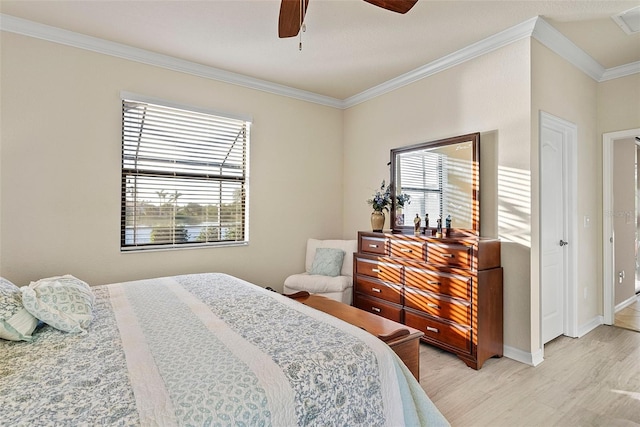 bedroom with ornamental molding, light wood-style floors, baseboards, and a ceiling fan