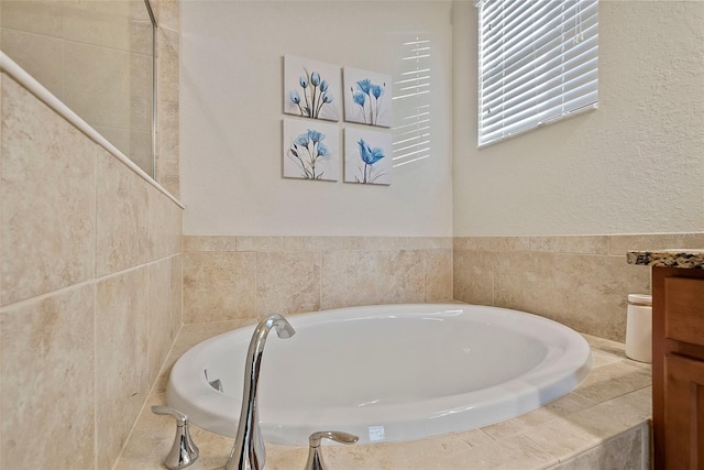 bathroom featuring a garden tub and vanity