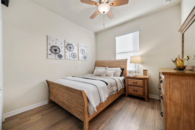 bedroom featuring light wood-style flooring, baseboards, and a ceiling fan