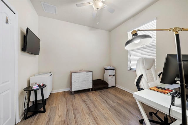 office featuring light wood-type flooring, ceiling fan, visible vents, and baseboards