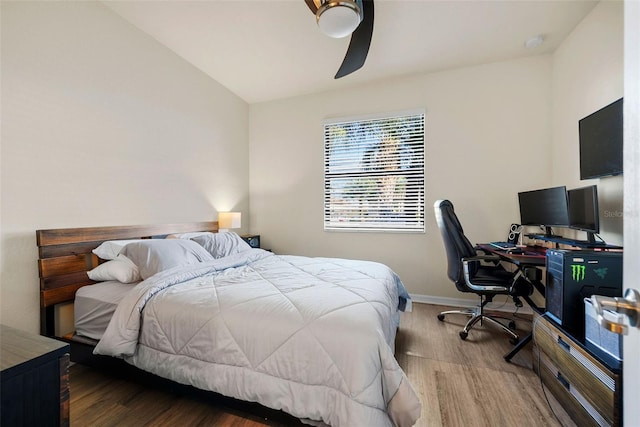 bedroom with lofted ceiling, ceiling fan, wood finished floors, and baseboards