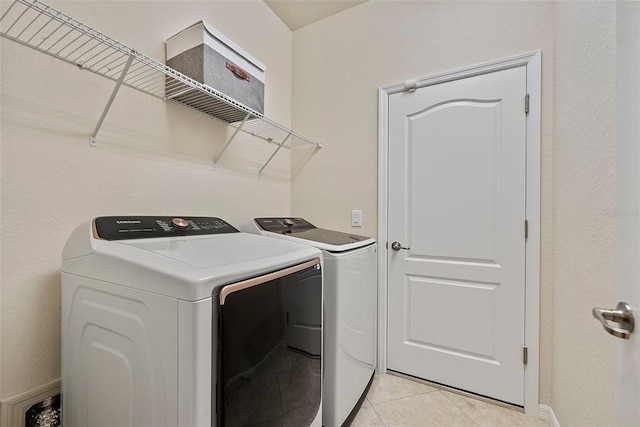 laundry area featuring laundry area, light tile patterned flooring, and washing machine and dryer